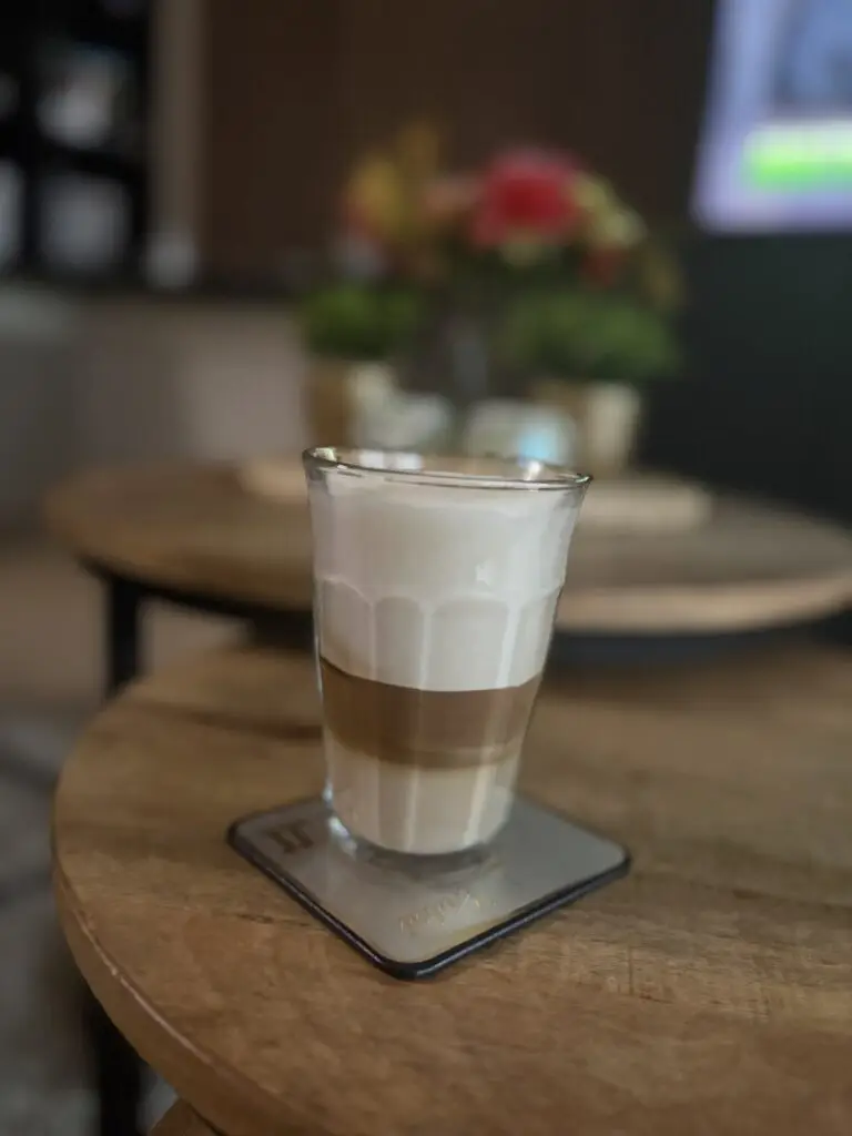 Latte macchiato met melklagen in een hoog glas