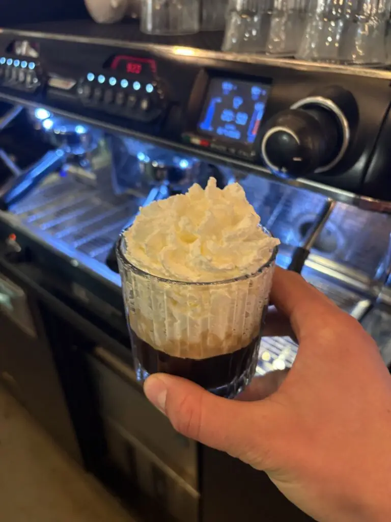 Koffie met een dikke laag slagroom in een glas
