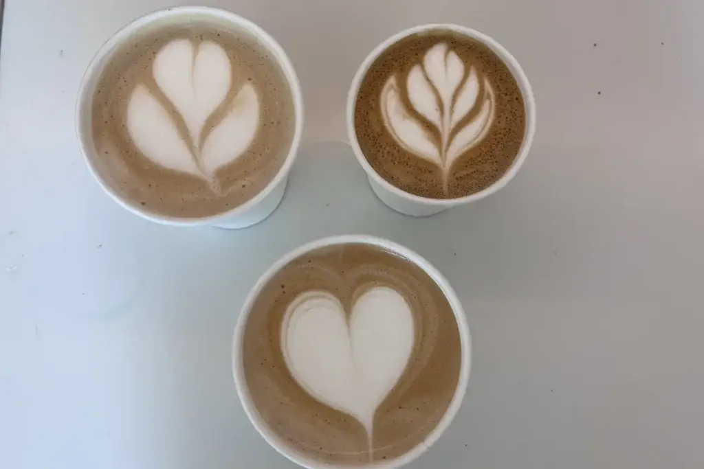 Drie kopjes met latte art, van bovenaf
