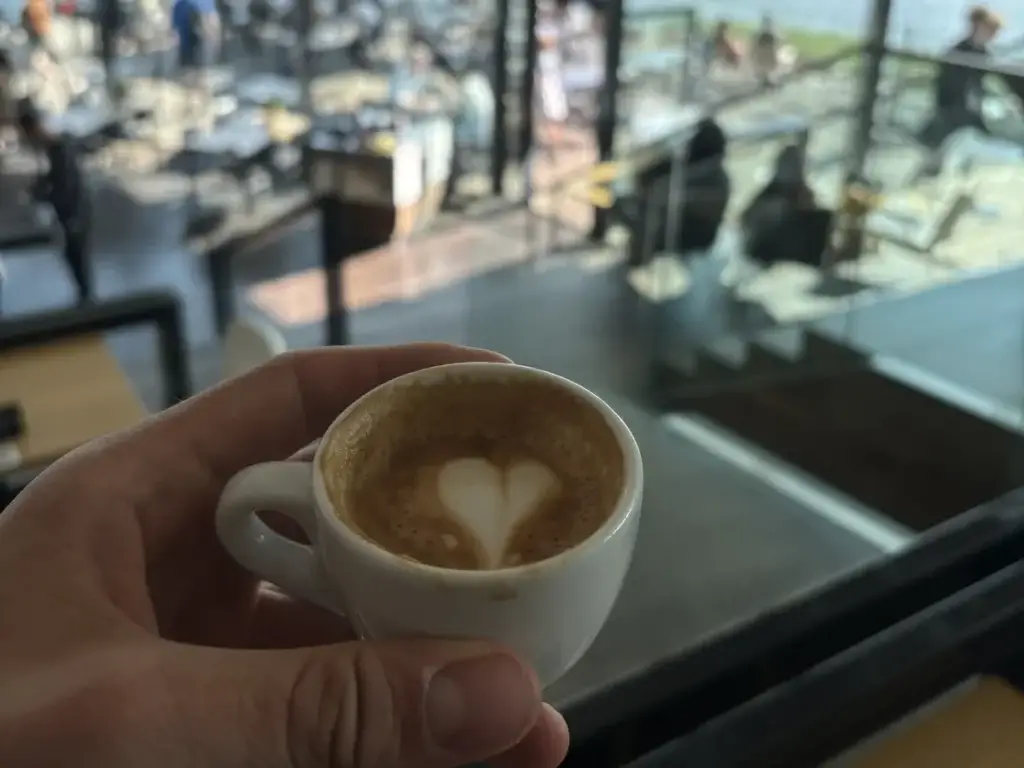 Espresso met latte art en uitzicht over het IJ