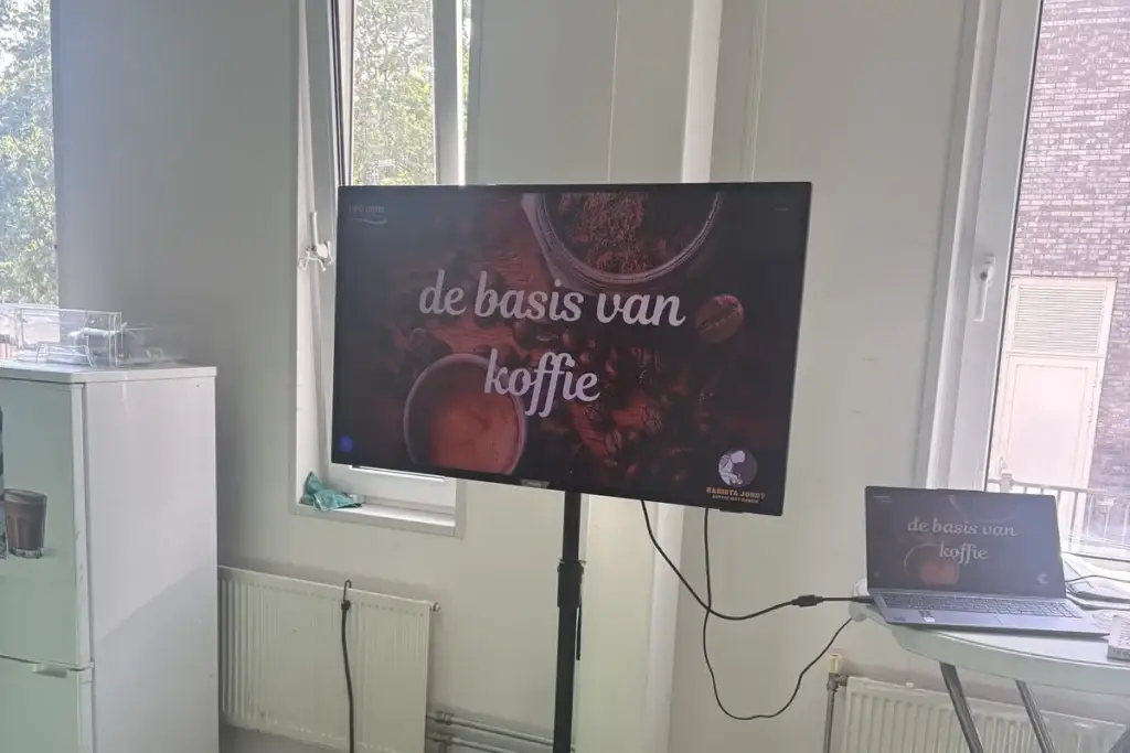 Workshopruimte met een scherm met de tekst de basis van koffie